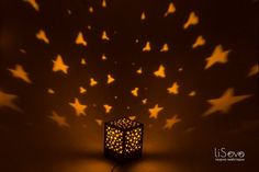 a lit up lantern in the shape of stars