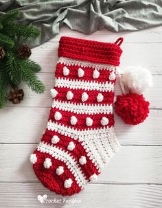 a crocheted christmas stocking with a pom - pom on top