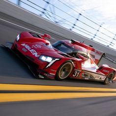 a red race car driving down the track