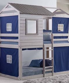 there is a bunk bed with blue sheets on the top and bottom floor, next to a window