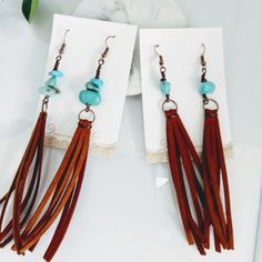 two pairs of earrings with tassels and turquoise beads on top of each other