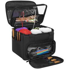 an open black bag with knitting supplies inside it on a white background, including yarn and crochet hooks