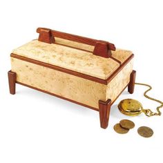 a wooden box with some gold coins on the ground next to it and a chain