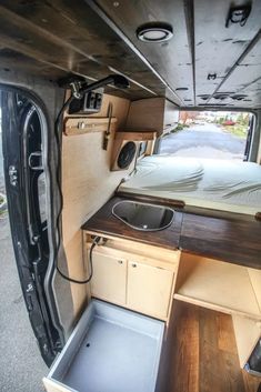 the inside of an rv with its bed and sink in it's center area