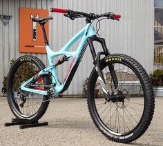 a blue mountain bike parked in front of a building