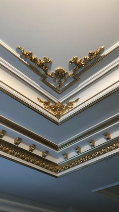 the ceiling is decorated with gold and white trim