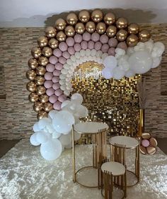 balloons and chairs are set up in front of a wall with gold, white and pink decorations