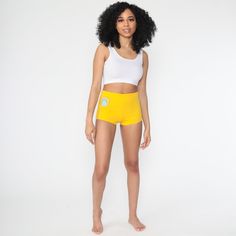 "Vintage 70s shorts in yellow with a Yosemite, California patch. Every garment we sell is authentic vintage and one-of-a-kind! You will receive the exact item photographed. Condition: Very good vintage with light general wear. Has some loose stitching along the hem Best fits women's: Extra small Tag: mcgregor Material: Feels like a nylon blend MEASUREMENTS Taken from seam to seam while the garment is lying flat. Double the armpit, waist, and hips For reference, model is 5'6\" and measures 32-25- Retro Stretch Bottoms Short Length, Retro Stretch Bottoms In Short Length, Fitted Mustard Bottoms For Summer, Yellow Stretch Bottoms Of Short Length, Yellow Stretch Short Length Bottoms, Stretch Yellow Bottoms In Short Length, Retro High Waist Beach Bottoms, Yellow Summer Shorts With Short Leg, Yellow Stretch Bottoms Short Length