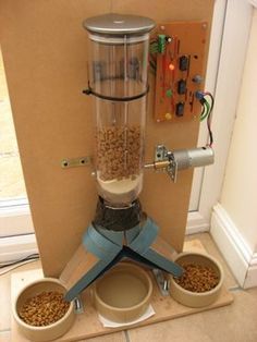 a dog food dispenser with three bowls on the floor