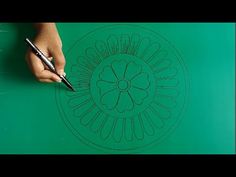 a person drawing on a green surface with a pen