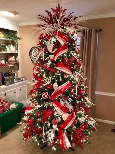 a christmas tree decorated with red and white ribbons