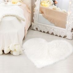 a bedroom with white fur rugs on the floor and a mirror in the corner