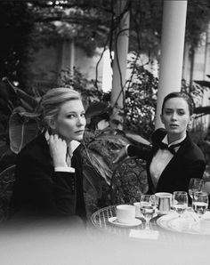 black and white photograph of two women sitting at a table with wine glasses in front of them