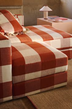 two red and white checkered couches in a living room with a lamp on the end table