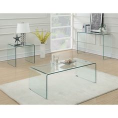 three glass tables sitting on top of a white rug