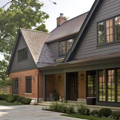 a large brick house with black shingles and windows