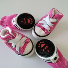 four pairs of pink and white shoes with paw prints on the soles are shown