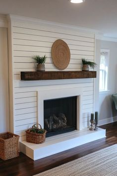 a living room with a fire place and baskets on the fireplace mantel in front of it