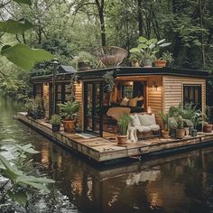 a houseboat is floating on the water with lots of greenery in front of it