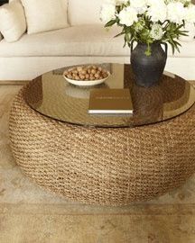 a coffee table with a bowl of nuts on it and a vase filled with flowers