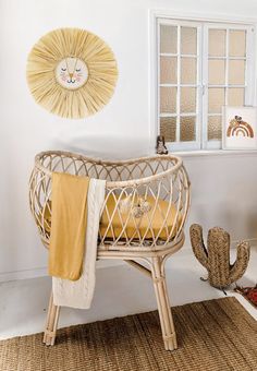 a baby's crib in the corner of a room next to a cactus