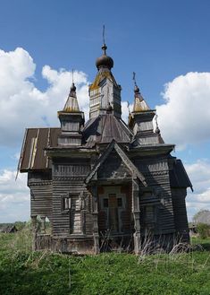 an old wooden house with two towers on the roof and three spires at the top