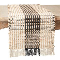 a black and white checkered table runner sitting on top of a wooden bench next to a piece of wood