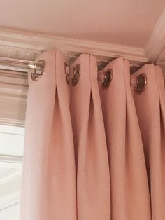 pink curtains hanging on the side of a window