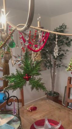 a christmas tree with ornaments hanging from it's branches in a dining room area