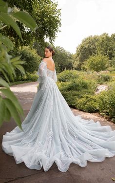 a woman in a wedding dress is standing outside