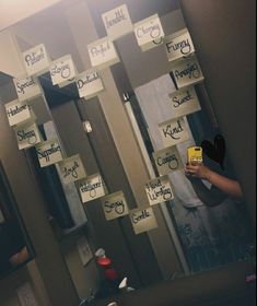 a person taking a selfie in front of a mirror with sticky notes on it