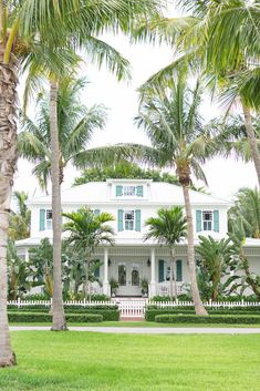 a large white house surrounded by palm trees