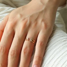 a woman's hand with a ring on her finger and two diamonds in the middle