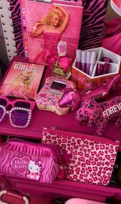 a pink table topped with lots of items