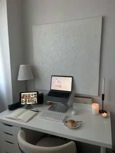 a laptop computer sitting on top of a white desk