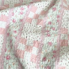 a pink and white quilt with flowers on it