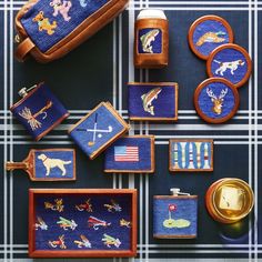 various embroidered items are displayed on a blue and white plaid tablecloth, with gold trimmings