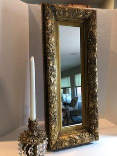 a candle and mirror sitting on a table