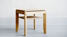 a small wooden table sitting on top of a white floor