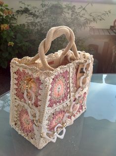 a crocheted bag sitting on top of a glass table