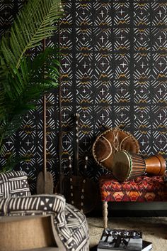 a living room with black and white wallpaper, patterned furniture and plants in the corner