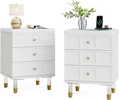 two white dressers with gold legs and a vase on the top, one has a plant in it