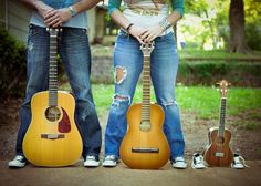 two people standing next to each other holding guitars