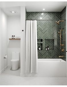 a bathroom with green tile and white fixtures, including a shower curtain in the corner