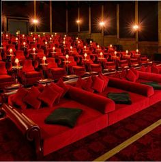 rows of red seats with candles lit in the middle and one row on each side