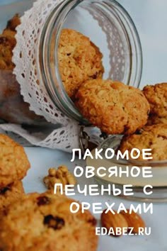 some cookies are in a glass jar on a white tablecloth with words above it