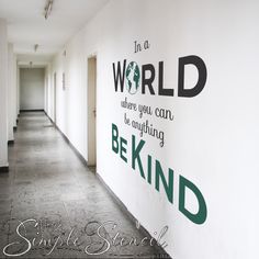 there is a sign on the wall that says in a world where you can be anything behind