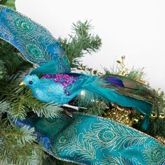 a blue bird ornament sitting on top of a christmas tree