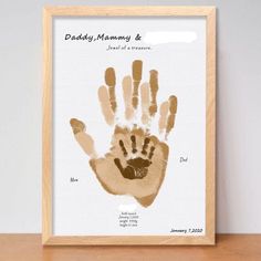 a wooden frame with a handprint on it that says daddy, mommy and me