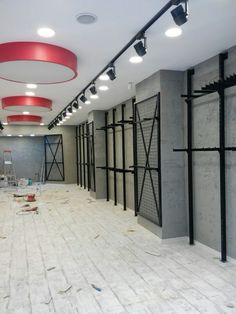 an empty room is being remodeled with white tile and red accents on the ceiling, along with exposed lighting